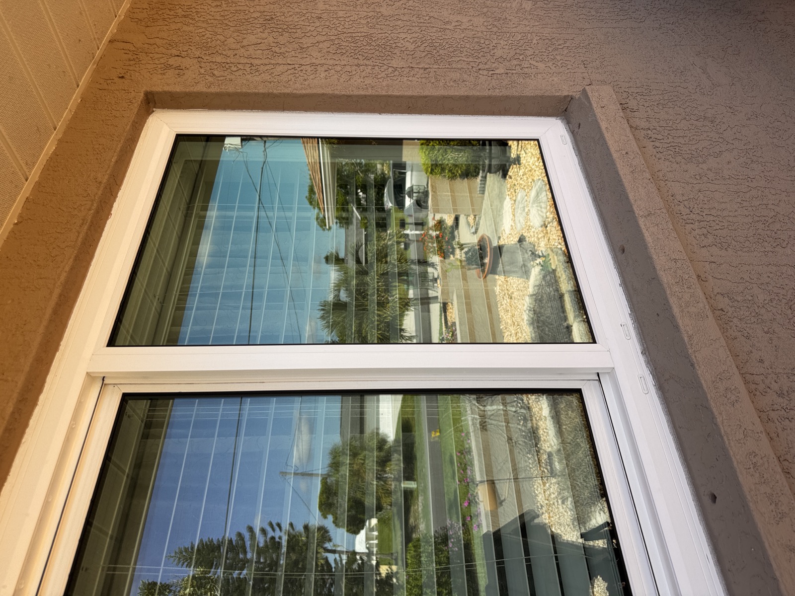 Clean residential window glass reflecting trees and blue sky
